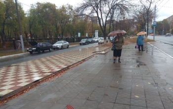 Оренбуржцы ждут общественный транспорт под дождем на промозглом ветру